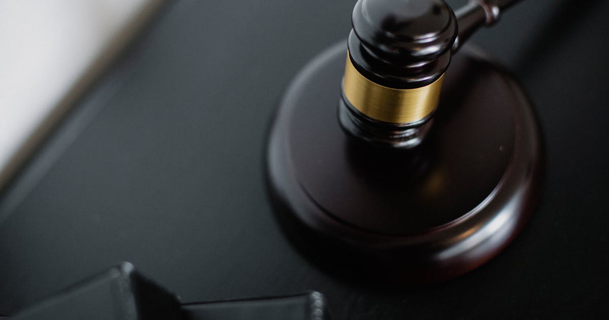 Close-up of a wooden judge's gavel on a dark desk symbolizing a court ruling