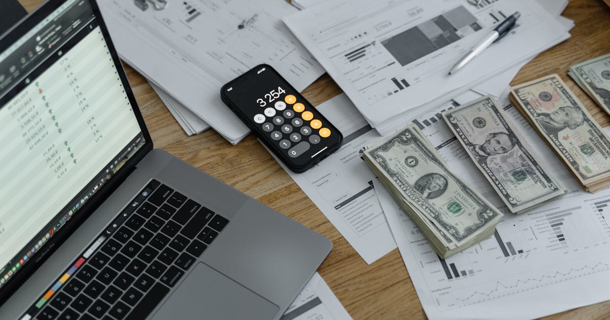 Banknotes and calculator on table representing the financial cost of TCPA non-compliance
